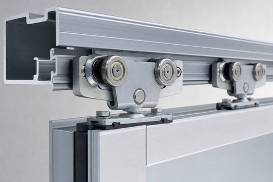 Close-up of tandem aluminum sliding door roller assemblies on an extruded aluminum track